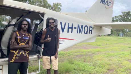 Laynhapuy Homelands School students Yalanba and Vernon with VH-MQR  in the Arnhem Land community of Gurrumuru.