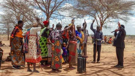 Pastor Robinson engaging in prayer with the local community near Chidudu airstrip.