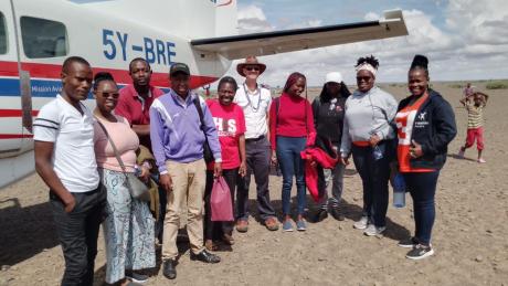 From left: Wanyama Simiyu, Alice Kamau, Victor Ogembo, Leonard Bett, Janice Nelima, MAF Pilot Daniel Loewen-Rudgers, Vane Memba, Gloria Musimbi, Corazon Nafula and Grace Nuigai after landing in Kargi airstrip for the med/vet mission.