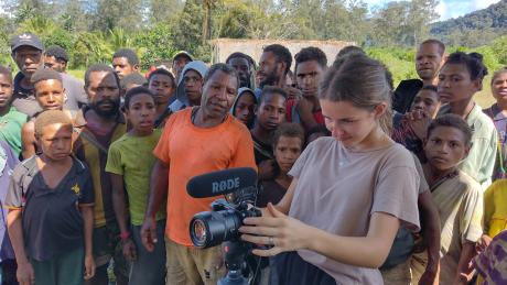 Ashley Leyenhorst video interviewing with a crowd of people behind her