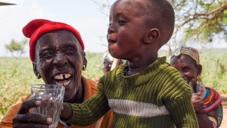 A happy child savors a refreshing glass of clean water.