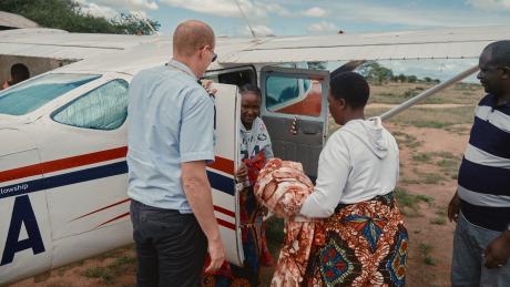 A jovial Neema returns to Malambo with her newborn baby. ~ Photo credit: Justin Maclean