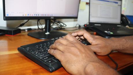 Hands working on a computer desktop