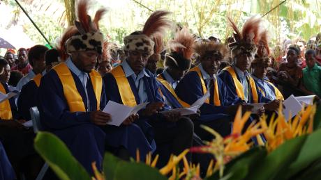 Mougulu grade 12 graduates in their gowns and with traditional head dresses