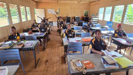 Happy students in classroom at Mougulu Secondary School with new chairs