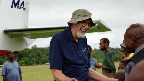 Dan Shaw at Honinabi talking with the local CHW next to the MAF aircraft