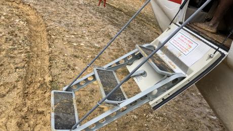 muddy airstrip, muddy stairs into the aircraft