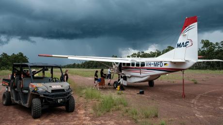 MAF aircraft and offroad buggy on red gravel airstrip