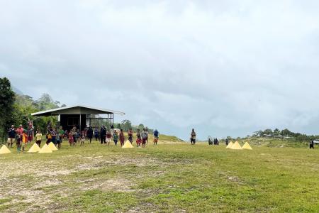 Bak airstrip clouded in, with people standing around watching...