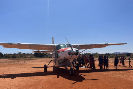 Crowd gathered around MAF plane on airstrip