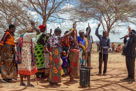 Pastor Robinson engaging in prayer with the local community near Chidudu airstrip.