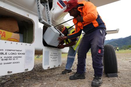 Telefomin traffic officer Ben Peter loading a vaccine eski into the aircraft