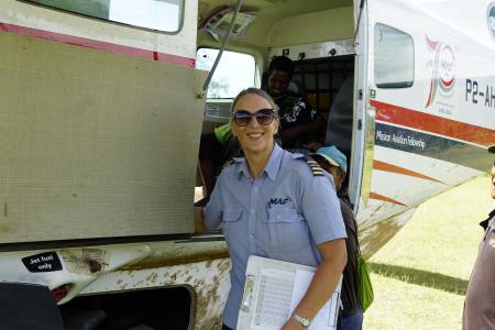 MAF Pilot Glenys Watson smiling beside MAF plane.