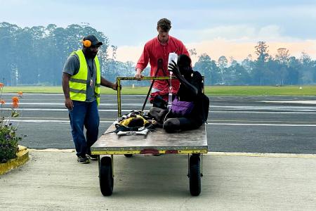 medevac patient and his dad getting moved into Hagen base on a trolley by traffic officer and Nathaniel