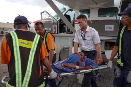 Patrick Keller, MAF pilot carrying a patient with the ground OPS