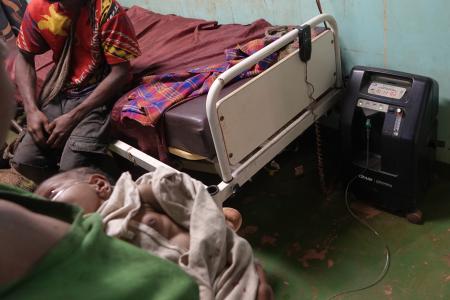 Mougulu health centre: breast feeding baby attached on oxygen concentrator 