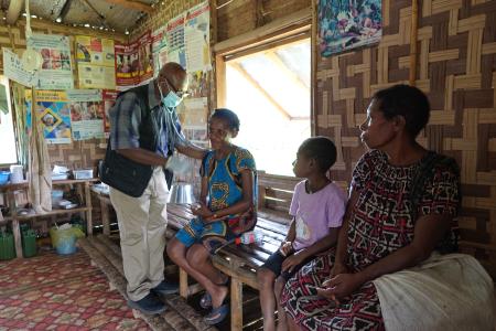 CHW Jamie Gudego examining a patient in his aidpost