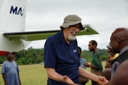 Dan Shaw at Honinabi talking with the local CHW next to the MAF aircraft