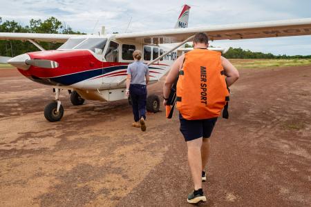 Physiotherapist and pilot walking toward aircraft