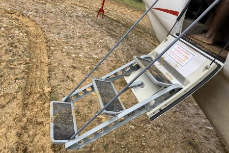 muddy airstrip, muddy stairs into the aircraft