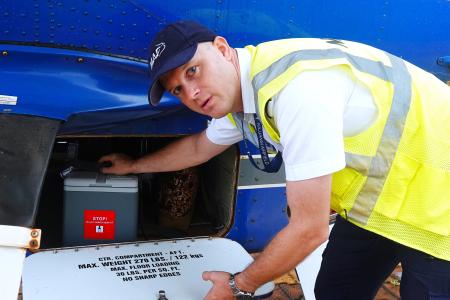Pilot Wim Hobo loads vaccine on a MAF plane