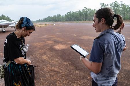 Two people standing on airtstrip in rainy weather