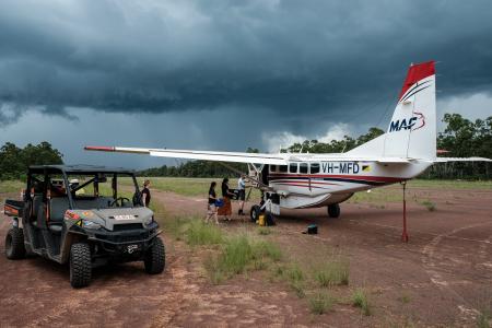MAF aircraft and offroad buggy on red gravel airstrip