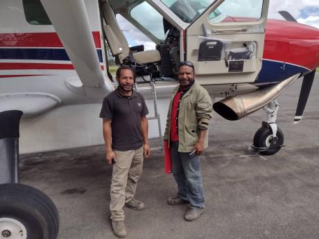 Hapson and his friend ready to board the plane to Bomai