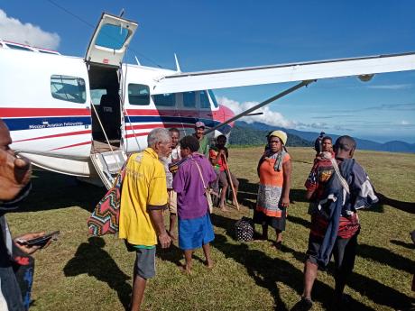 the first patients flown out of Nankina mingling around the aircraft