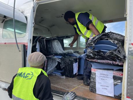 traffic officers at Mt Hagen loading chairs for Mougulu Sec School
