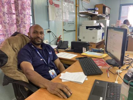 Clyde Johnny posing at his desk