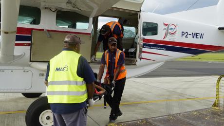 Medevac patient being unloaded by MAF Mt Hagen base staff.