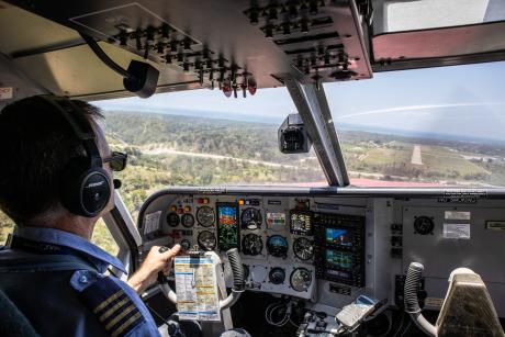 A pilot in the cockpit lining up for final approach