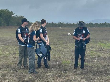 People standing on grass airstrip