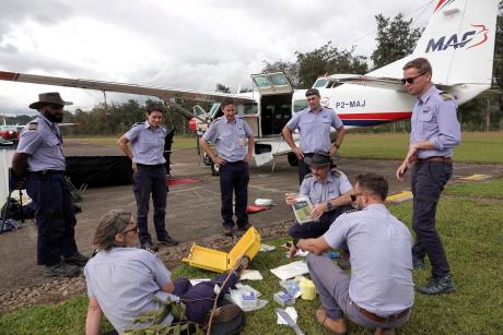 emergency exercise at pilots meeting with pilots gathered around survial and first aid kit
