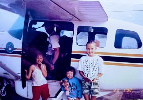 Pilot and duaghters in fron of plane