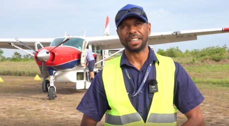 Simon Wakili stands in front of the MAF plane in Balimo
