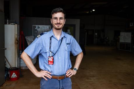MAF pilot standing in hangar doorway 