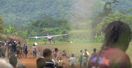 MAF plane landing at Yenkisa airstrip with people in the foreground