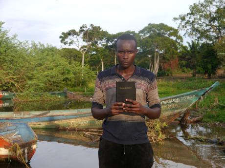 Farouk Mugisha displays his first Bible.