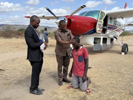 John Nhahugi being baptized by Thomas Philido and Bonfers Lugusha