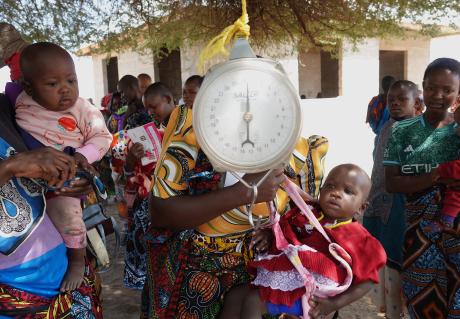 Children being weighed before vaccination