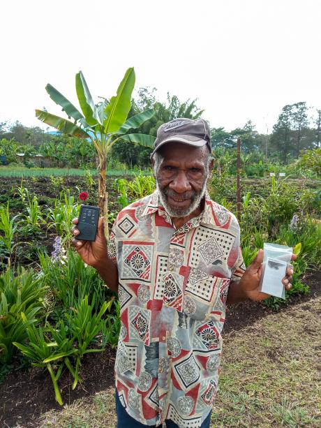 An elderly man holds an audio Bible
