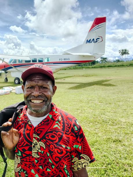 A man smiling next to a plane