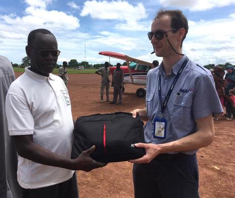 Pilot Phil handing laptop to Mizeguel