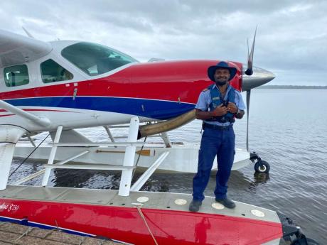 Joseph Tua standing on the floats after his first landing with the float plane