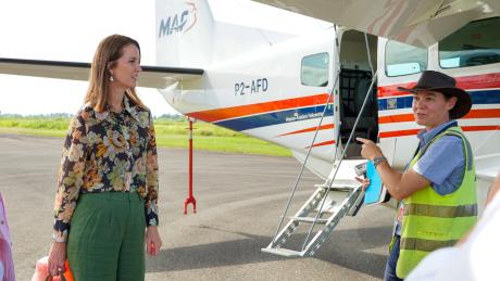A woman listens to a pilot before boarding a small plane