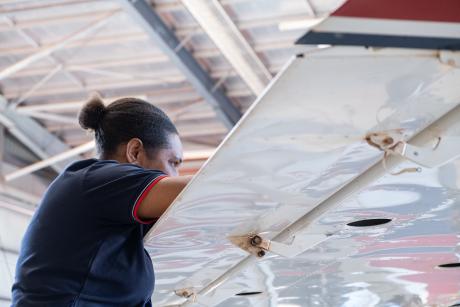 Engineer working on aircraft wing in hangar
