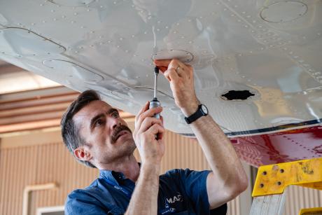 Aircraft mechanic inspects aircraft
