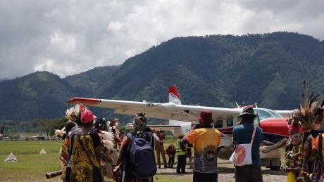 MAF Aircraft at Telefomin airstrip with people dancing